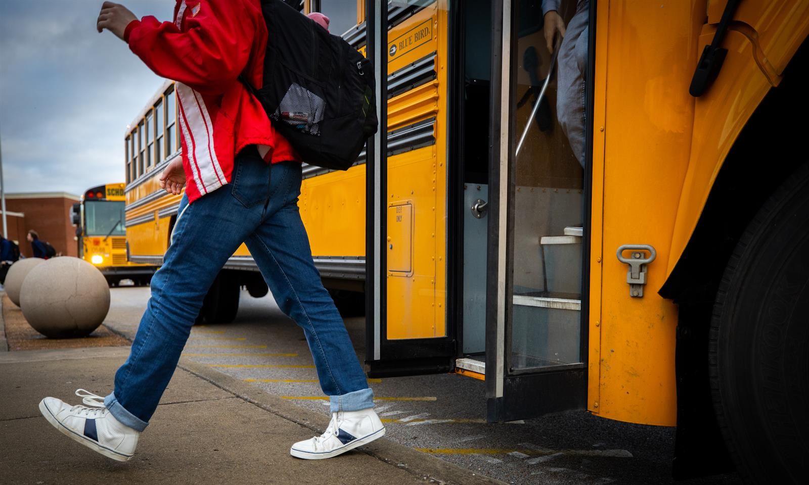 A student walking off a bus